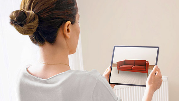 Woman viewing AR sofa on iPad